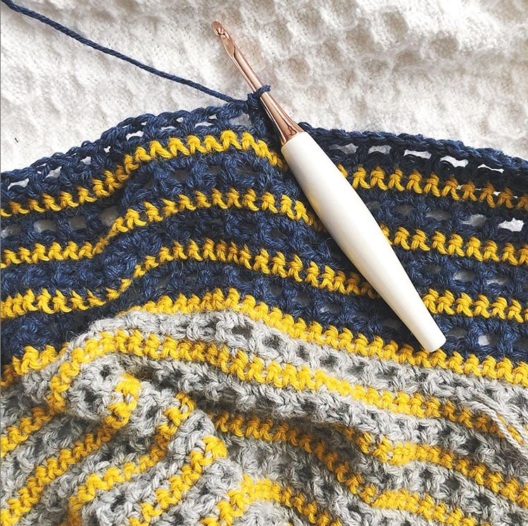 Try the Bronwyn Shawl, a FREE crochet triangle shawl pattern from TLYCBlog.com. Explore the range of crochet techniques and stitches in this asymmetrical triangle wrap. Elevate the experience by using luxurious yarns like merino wool and baby alpaca. Find the FREE crochet pattern on TLYCBlog.com with links to helpful tutorial videos. | TLYCBlog.com